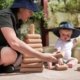 Baby-and-educator-using-natural-blocks-outdoors-700x467